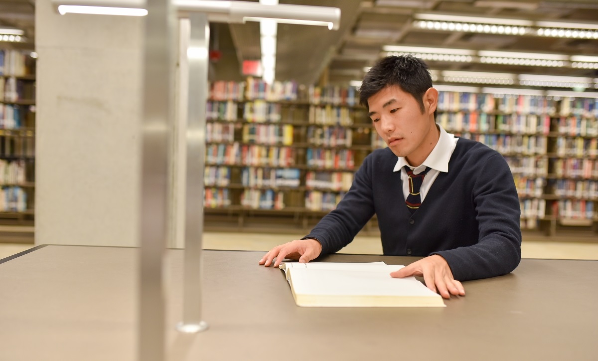 Photo of Take Morikawa tutoring from a book